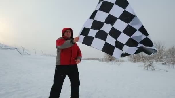 Hombre con bandera de meta en una pista de esquí — Vídeo de stock