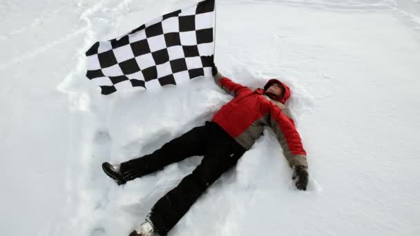 Чоловік з фінішним прапором на снігу — стокове відео