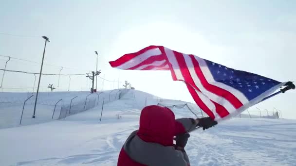 Hombre con bandera estadounidense en una pista de esquí . — Vídeos de Stock