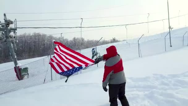 Homme avec drapeau américain sur une piste de ski — Video