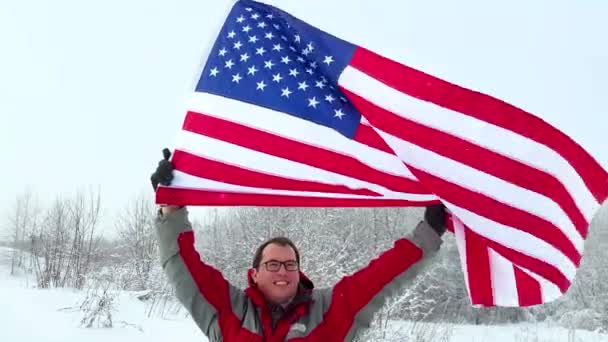 Hombre con bandera estadounidense en una pista de esquí — Vídeo de stock