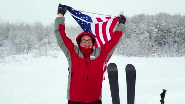 Hombre con bandera estadounidense en una pista de esquí — Vídeos de Stock