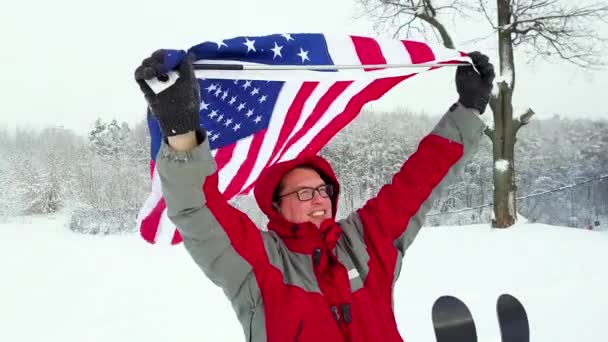 Человек с флагом США на лыжном склоне — стоковое видео