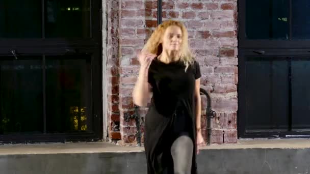 大きな窓の近くの台座にモダンなスタイルで黒服踊りの女性 — ストック動画