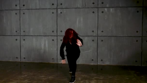 Рыжая женщина делает хип-хоп рядом со стеной — стоковое видео
