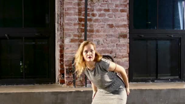 Young blond woman performs in grey clothes near by window — Stock Video