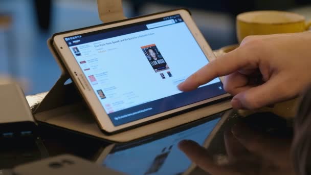 Homme explorant IKEA site Web à la recherche de meubles en utilisant tablette PC dans le café . — Video