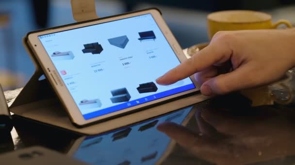 Ikea 웹 사이트 카페에서 태블릿 pc를 사용 하 여 가구를 찾고 탐구 하는 남자. — 비디오