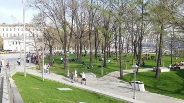 vatandaşların ve turistlerin Moskova'da bir Zaryadye parkta, arka planda Kremlin olduğunu