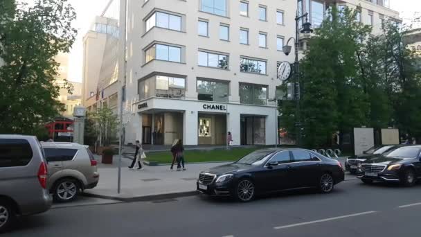 Schot van luxe goederen boutique Chanel winkel vooraan in Petrovka st. zoals shoppers voorbij op de voorgrond. — Stockvideo