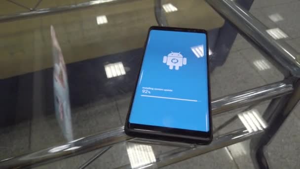 Icona del logo del robot Android sullo schermo dello smartphone durante l'installazione dell'aggiornamento — Video Stock