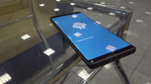 Εικονίδιο με το λογότυπο Android ρομπότ στην οθόνη του έξυπνου τηλεφώνου κατά τη διάρκεια της εγκατάστασης της ενημερωμένης έκδοσης — Αρχείο Βίντεο