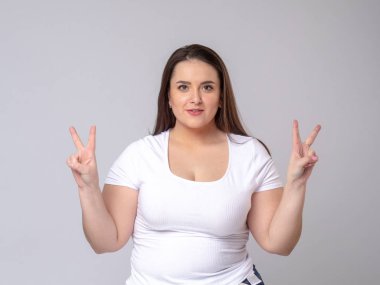 Stüdyoda poz veren uzun saçlı Şok Edici Model. v - sembolü