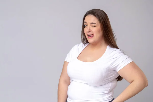 Plus Size Model with long hair posing in studio. Winks, blinks — Stock Photo, Image