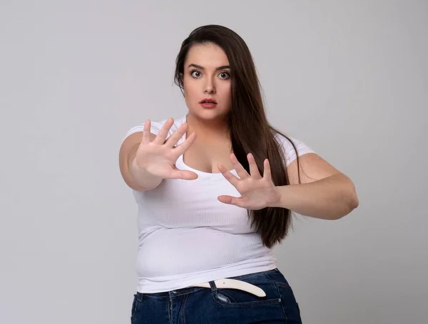 Συν μέγεθος μοντέλο με μακριά μαλλιά gesturing κανένα σήμα στο στούντιο. — Φωτογραφία Αρχείου