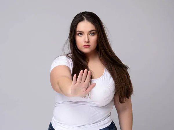 Plus Size Model with long hair gesturing no signal in studio. — Stock Photo, Image