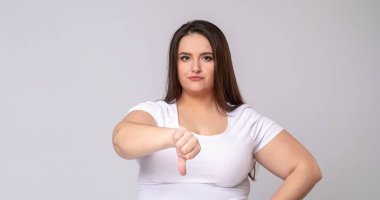 Stüdyoda poz veren uzun saçlı bir manken. Başparmaklar aşağı