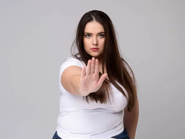 Plus Size Model with long hair gesturing no signal in studio. — Stock Photo, Image