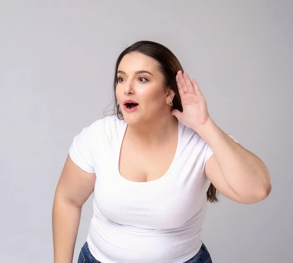 Modelo Shocked Plus Size com cabelo comprido posando em estúdio. Ouve... — Fotografia de Stock