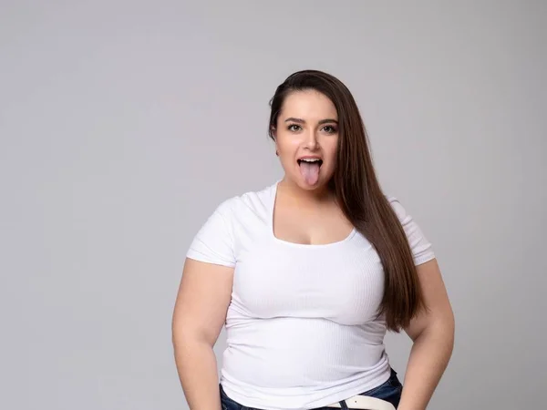 Plus Size Modello con i capelli lunghi Grimacing, tirando le guance . — Foto Stock