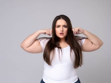 Agresif Artı Boyut Modeli kulakları parmaklarla kapatır.