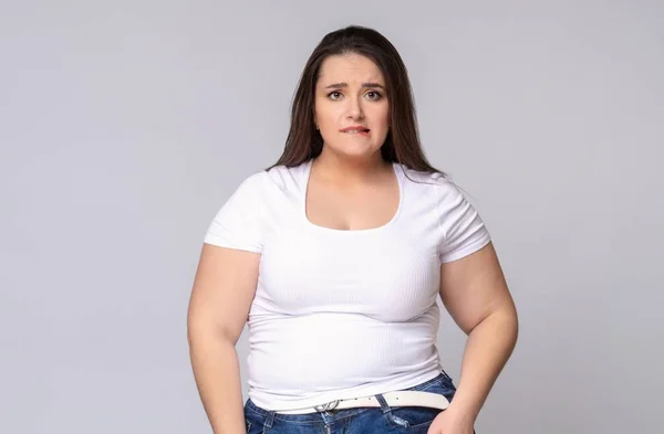 Plus Size Modelo com cabelos longos Grimacing, mordendo o lábio — Fotografia de Stock