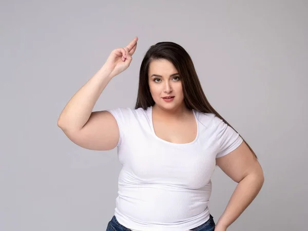 Portrait of serious plus size woman standing saluting with hand — Stock Photo, Image