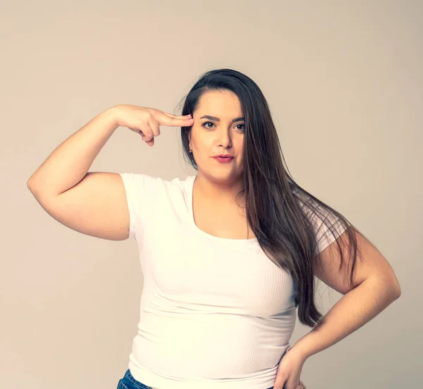 Portrait of serious plus size woman standing saluting with hand near head — Stock Photo, Image