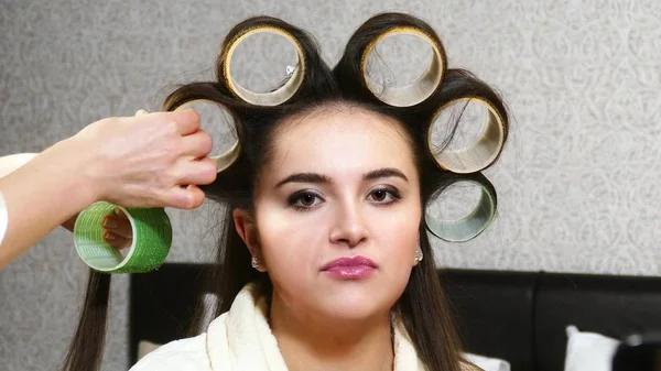 Friseurin zieht Lockenwickler an Frau mit langen Haaren an — Stockfoto