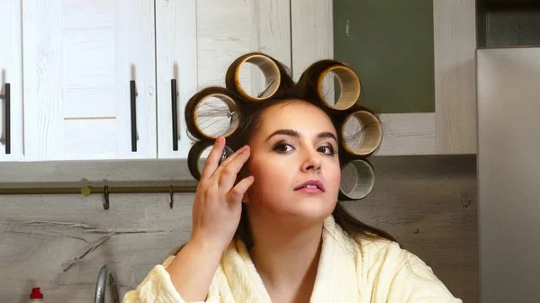 Femme posin avec des bigoudis dans la cuisine — Photo