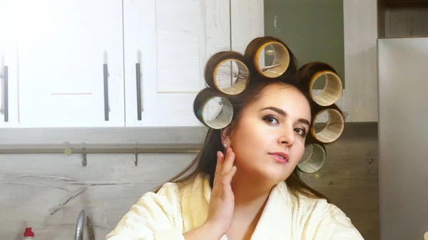 Mujer posin con rizadores en cocina — Foto de Stock