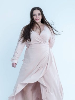 Plus Size Model plays with her long hair posing in studio