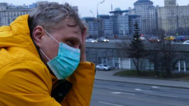 Sick man in medical mask outdoors