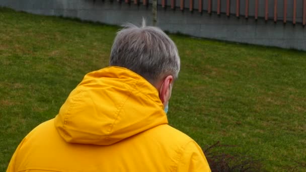 Adult man in medical mask sharply turns back to the camera — Wideo stockowe