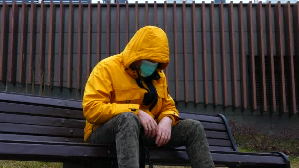 Sick man in medical mask falls on a bench without strength from illness — Stock video