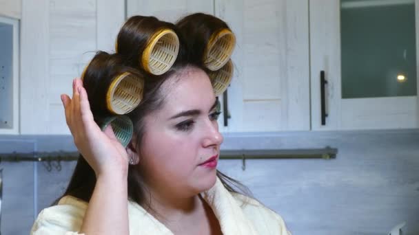 Mujer tocando grandes rulos en su cocina cabeza — Vídeo de stock