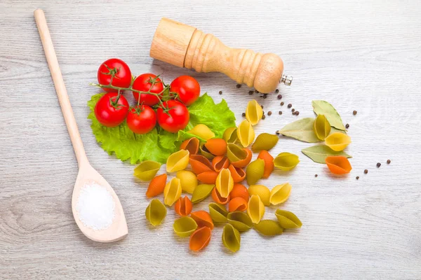 Těstoviny, rajčata a papriky na dřevěné pozadí — Stock fotografie