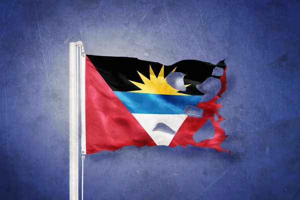 Poszarpane flaga Antigui i Barbudy flying przed tło grunge — Zdjęcie stockowe
