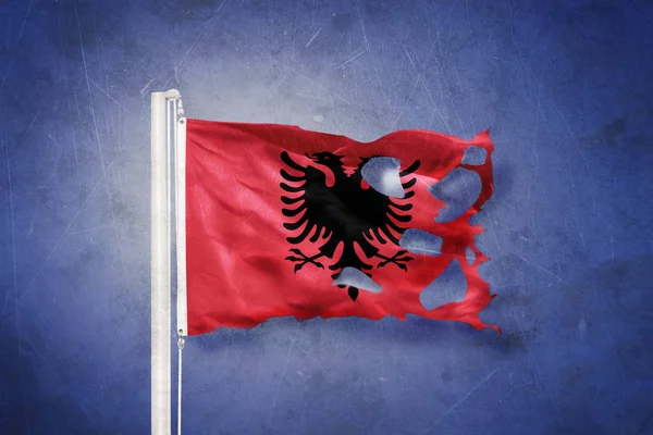 Gescheurde vlag van Albanië vliegen tegen grunge achtergrond — Stockfoto