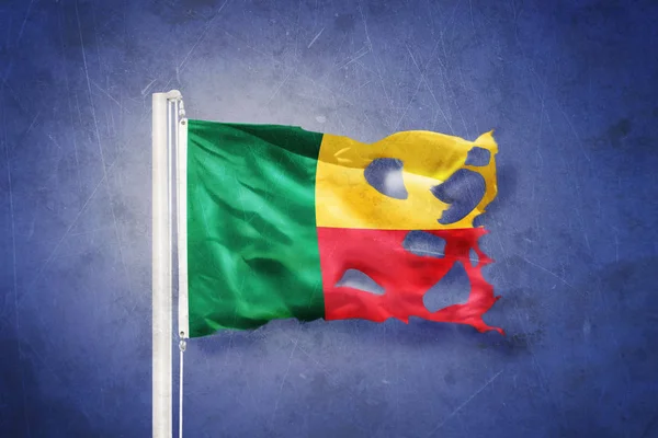 Torn flag of Benin flying against grunge background — Stock Photo, Image