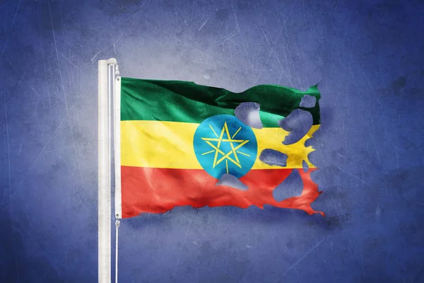 Torn flag of Ethiopia flying against grunge background — Stock Photo, Image