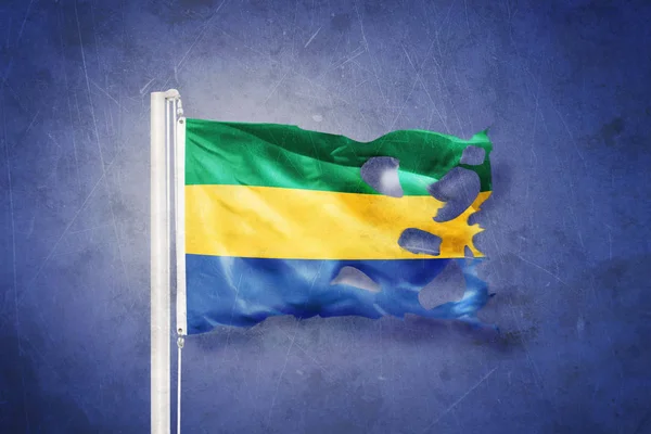 Sönderrivna flagga Gabon flyger mot grunge bakgrund — Stockfoto