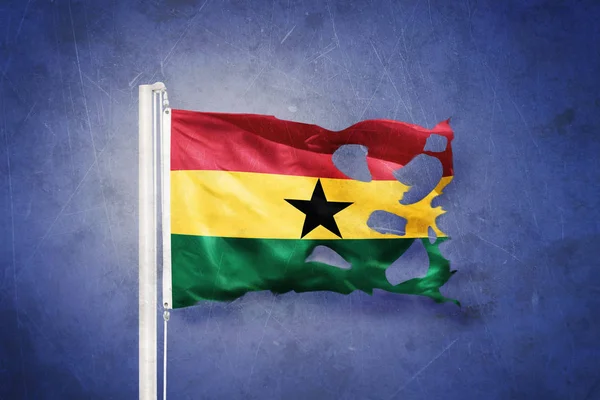 Gescheurde vlag van Ghana vliegen tegen grunge achtergrond — Stockfoto