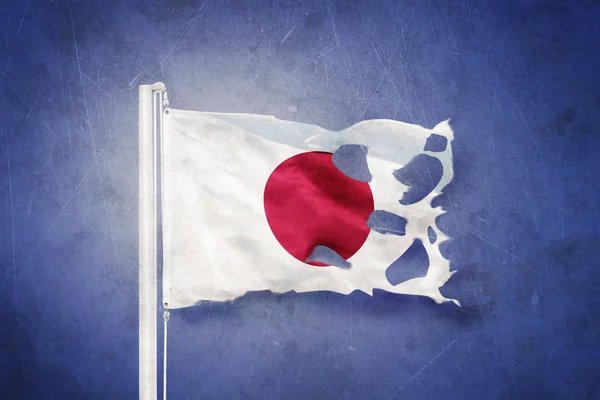 Sönderrivna flagga Japan flyger mot grunge bakgrund — Stockfoto