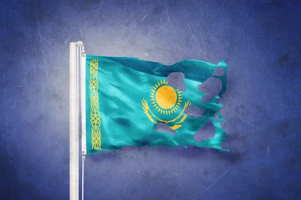 Torn flag of Kazakhstan flying against grunge background — Stock Photo, Image