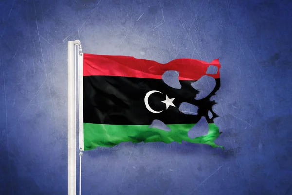 Torn flag of Libya flying against grunge background — Stock Photo, Image
