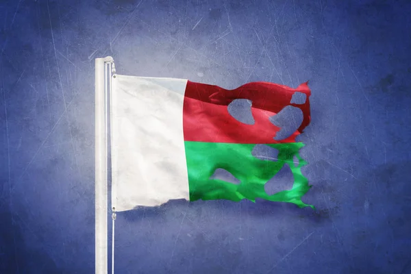 Gescheurde vlag van Madagaskar vliegen tegen grunge achtergrond — Stockfoto