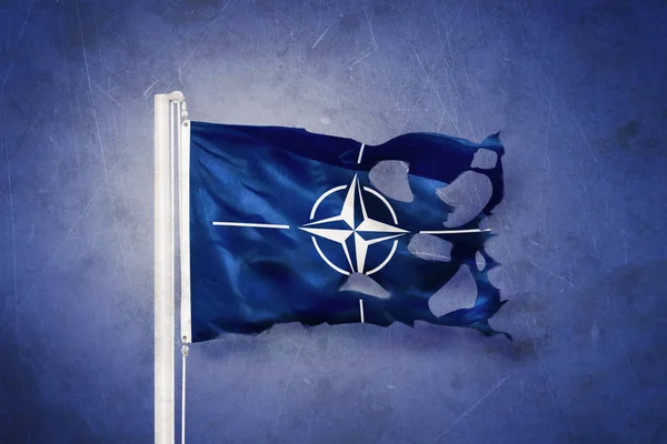 Разорванный флаг НАТО Североатлантического договора на фоне грандиозных событий — стоковое фото