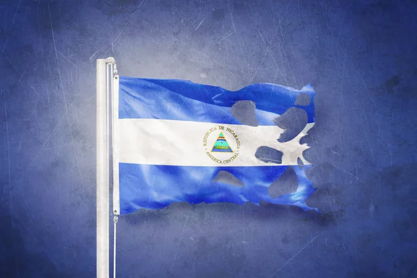 Poszarpane flaga Nikaragui flying przed tło grunge — Zdjęcie stockowe