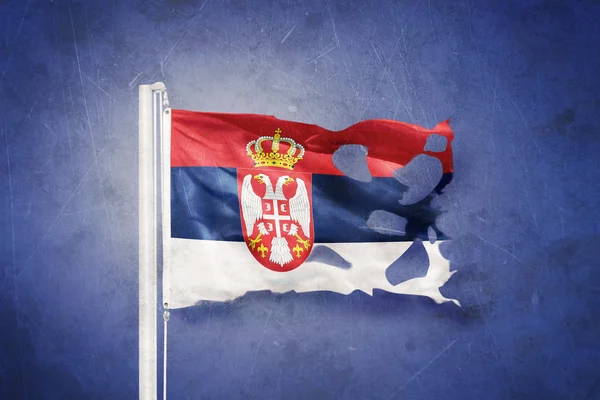 Torn flag of Serbia flying against grunge background — Stock Photo, Image